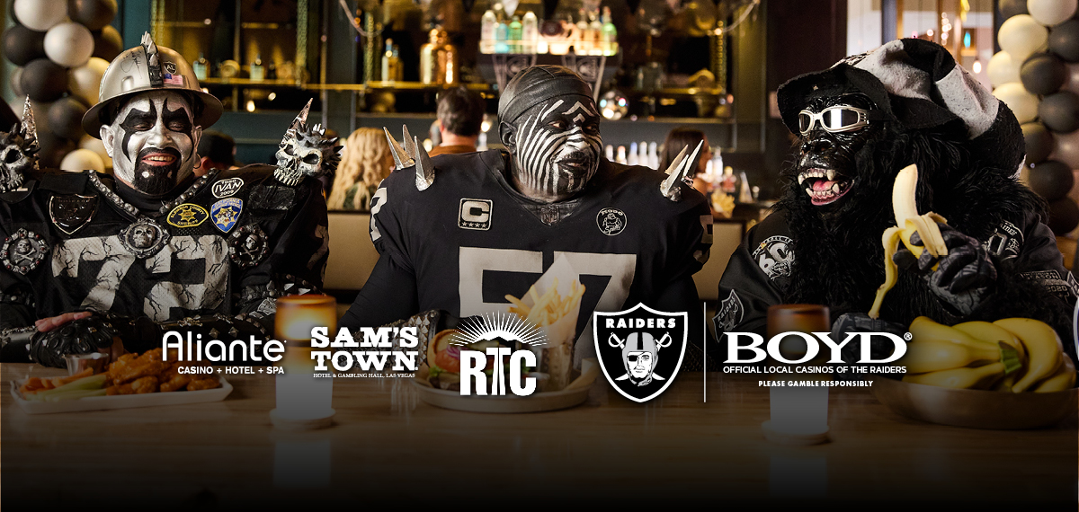 raiders fan eating with Aliante, Sam's Town, RTC, Raiders and Boyd logos