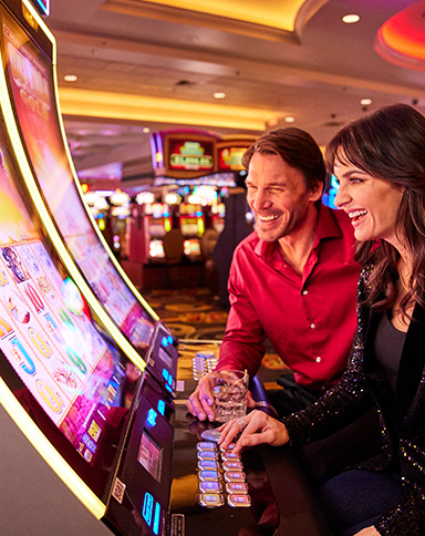 a couple at a slot machine playing