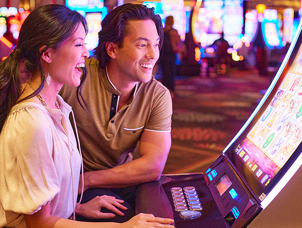 couple smiling at a Boyd slot machine