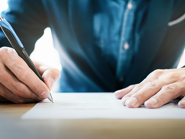 man writing on paper