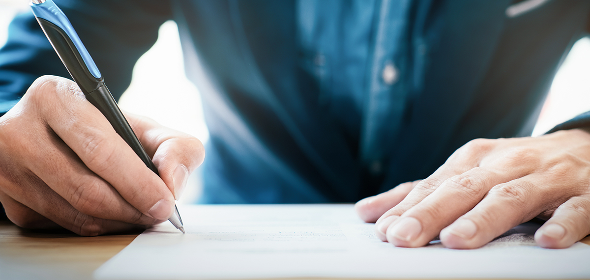 man writing on paper