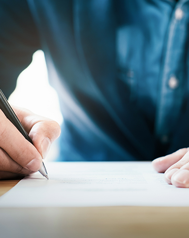 man writing on paper