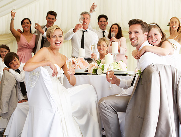 large wedding party smiling and sitting at the table