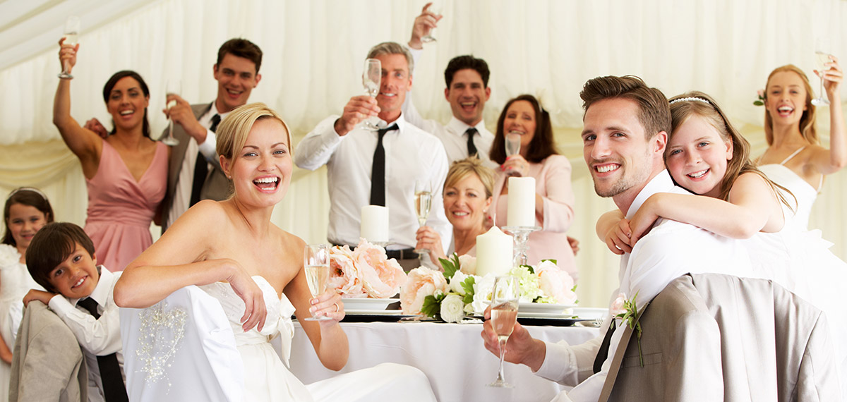 large wedding party smiling and sitting at the table