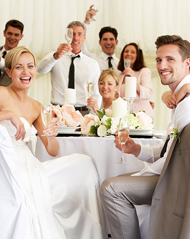 large wedding party smiling and sitting at the table