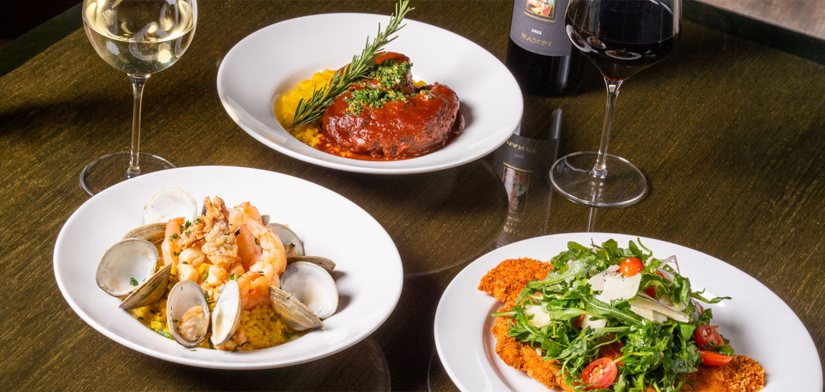 italian entrees, a glass and bottle of wine on a wooden table