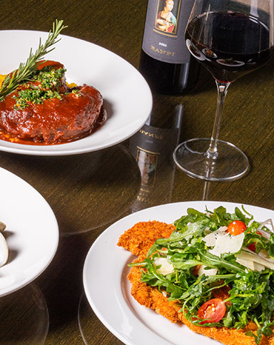 italian entrees, a glass and bottle of wine on a wooden table