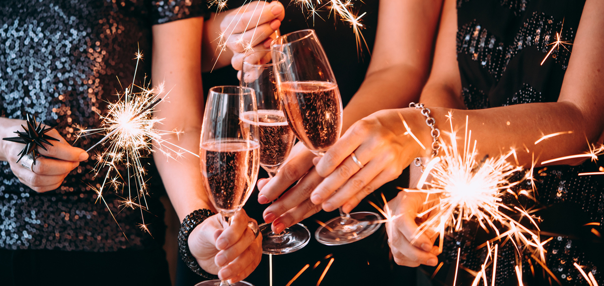 Three women with sparklers and champagne flutes