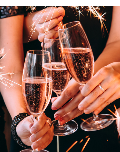 Three women with sparklers and champagne flutes