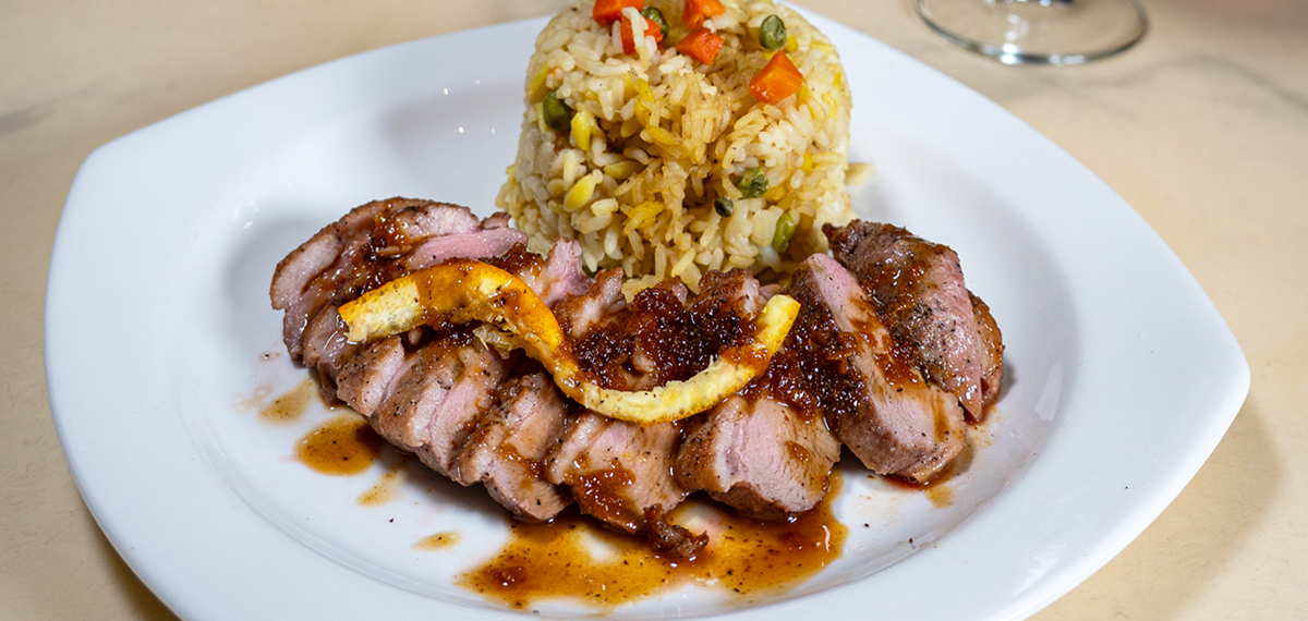 duck breast with orange sauce served with rice pilaf