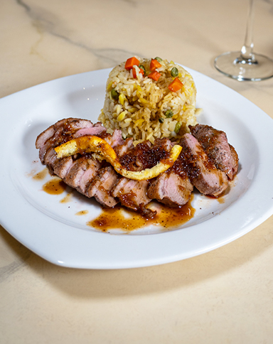 duck breast with orange sauce served with rice pilaf