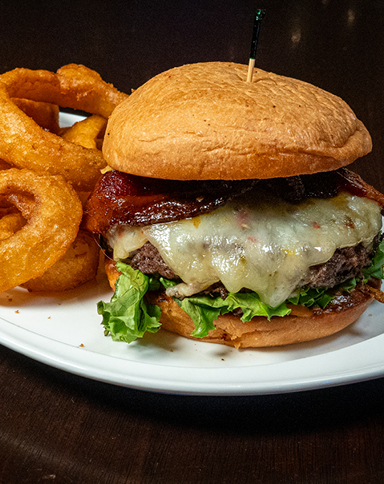 Wagyu Burger with grilled onions, pepper jack cheese, candied bacon, and house-made sauce