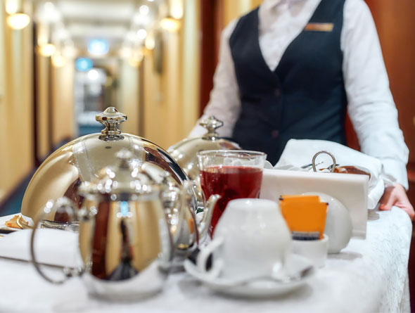 Room Service attendant pushing a cart with food