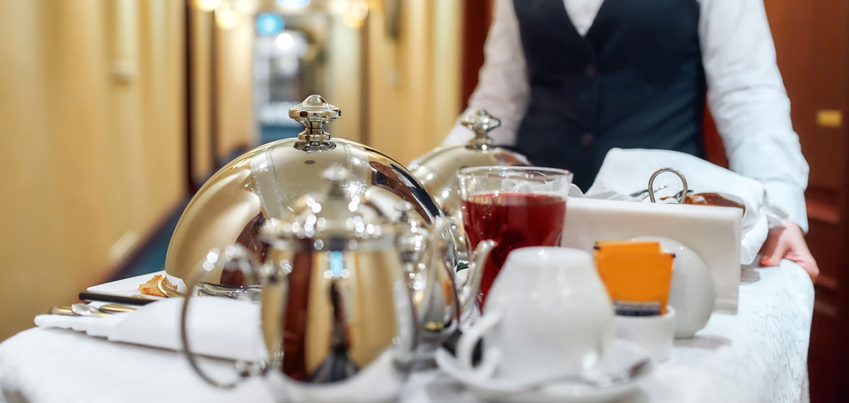 Room Service attendant pushing a cart with food