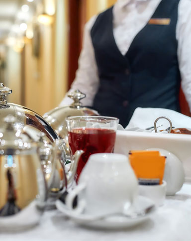 Room Service attendant pushing a cart with food