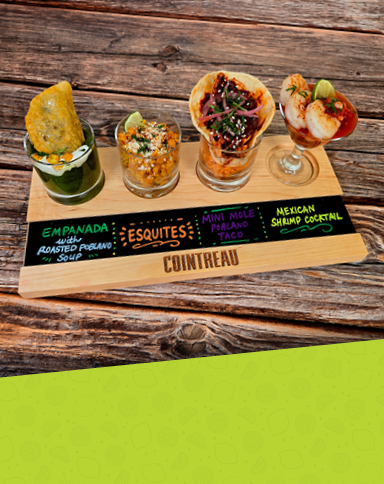 A wooden tasting board holds four small Mexican dishes: an empanada with green poblano soup, a cup of esquites, a mini mole taco, and a shrimp cocktail garnished with lime.