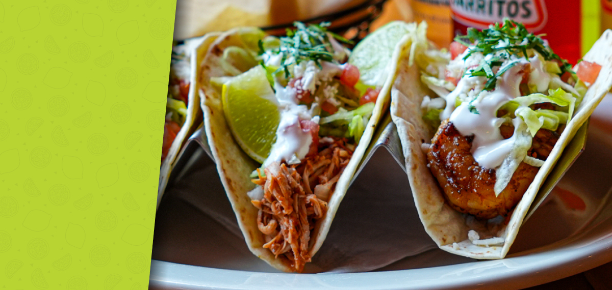A plate of tacos filled with seasoned ingredients and garnished with fresh toppings.