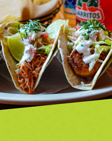 A plate of tacos filled with seasoned ingredients and garnished with fresh toppings.