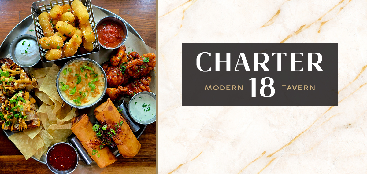 Charter 18 Modern Tavern appetizer platter with loaded nachos, cheese curds, chicken wings, dip and chips, and egg rolls.