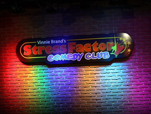 Stress Factory Comedy Club sign on the brick wall