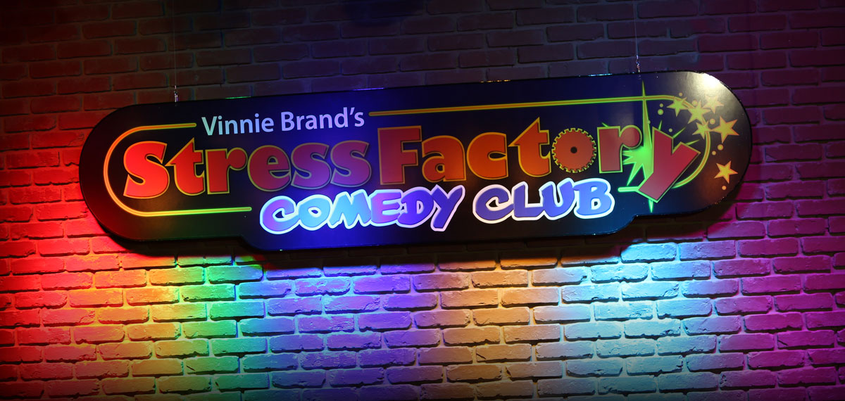 Stress Factory Comedy Club sign on brick wall
