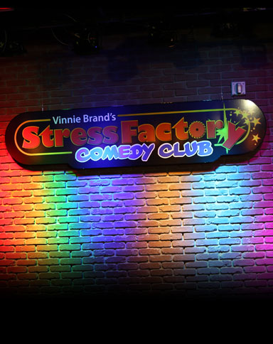 Stress Factory Comedy Club sign on brick wall