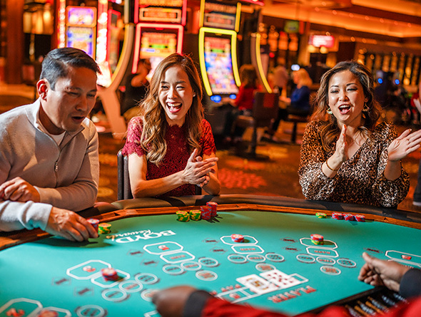 happy group of people playing baccarat in a Boyd casino