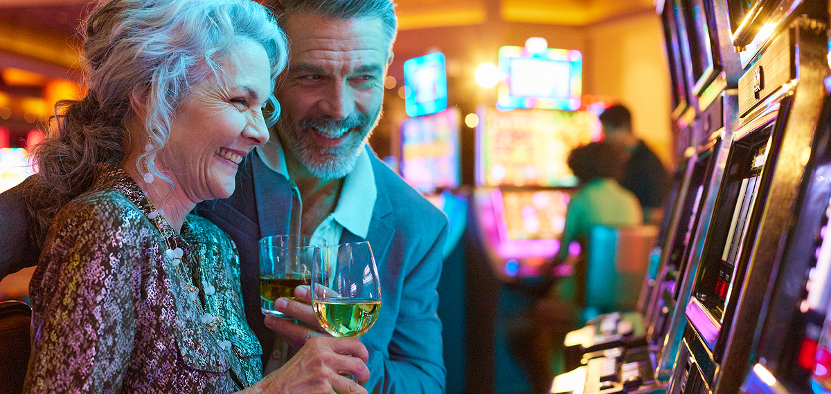 couple playing slots and drinking wine in a Boyd casino