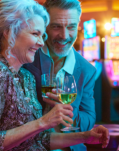 couple playing slots and drinking wine in a Boyd casino