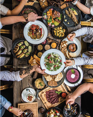 people eating a variety of food at the table