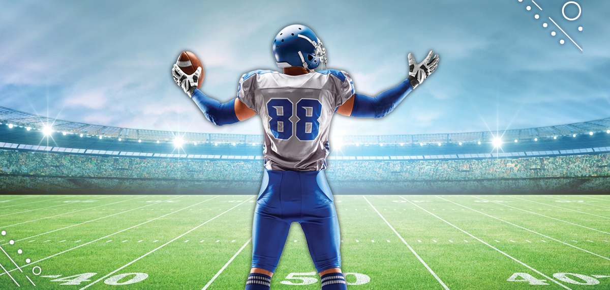 Man in Football pads holding a football
