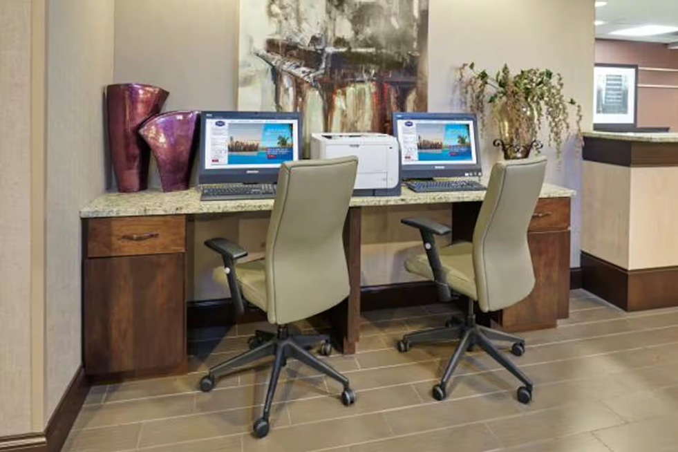business center with computers, desks, and chairs at paradice inn