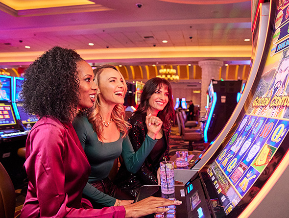 three women smiling in the casino playing slots